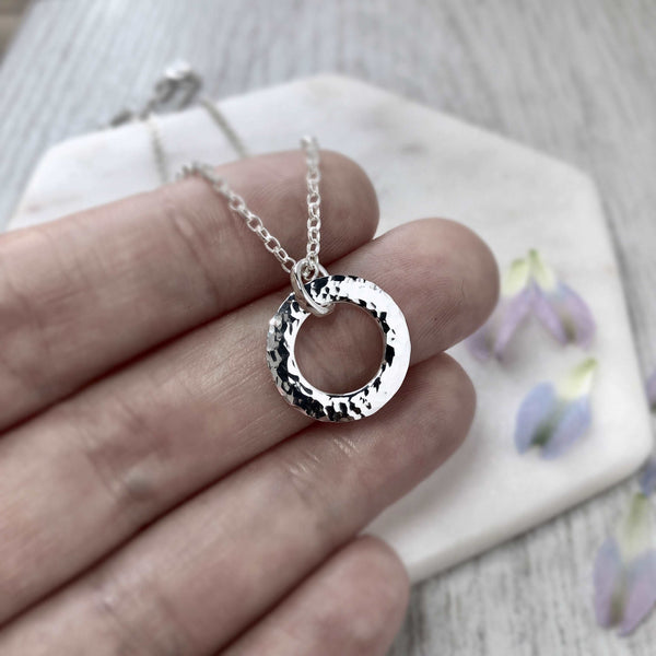 Simple, minimalist silver necklace with hammered finish