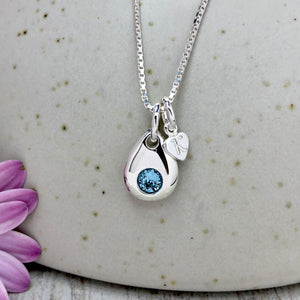 Silver teardrop pendant set with birthstone crystal. Also includes a tiny heart charm, engraved with one initial.