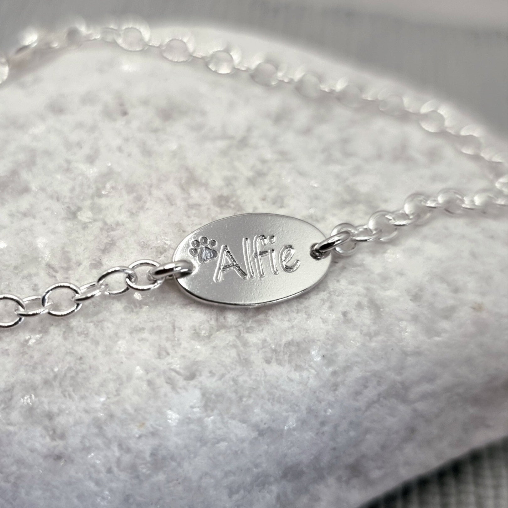 personalised pet name bracelet, engraved in sterling silver. Add between one and four oval charms to this dainty and lightweight silver bracelet. A perfect gift for any pet lover.