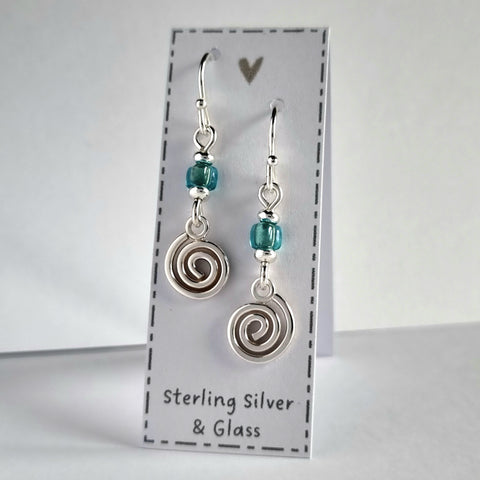 Handmade sterling silver spiral earrings with blue glass bead