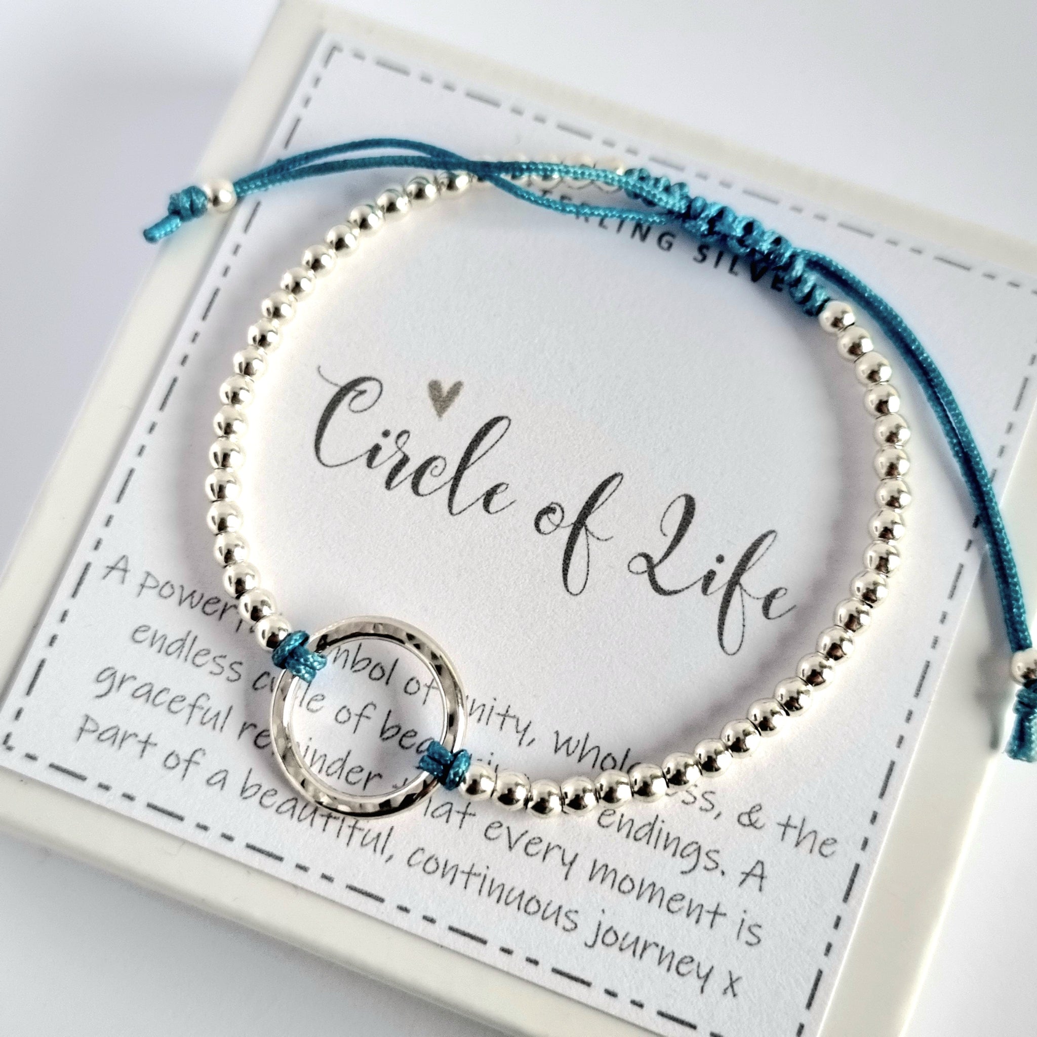 A delicate sterling silver Circle of Life bracelet, with an adjustable fit and a selection of twelve vibrant cord colours.